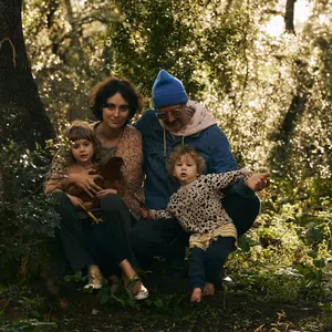 ema, tomas and their children sitting together among the trees