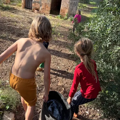 two of the children running barefoot through the trees