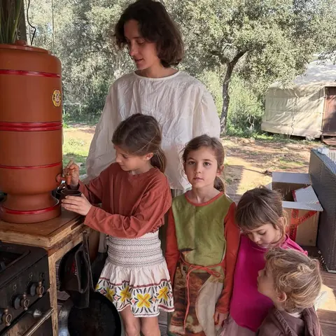 the family in the outdoor kitchen, children gathered round