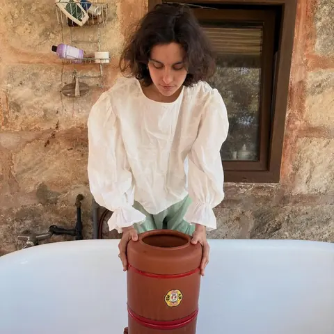 an old bathtub against a stone wall in the open air